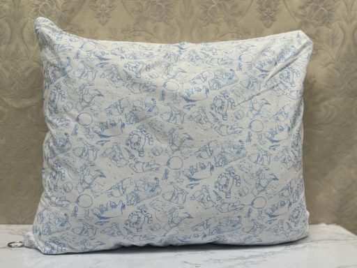 A decorative pillow with a blue floral pattern on a light background.