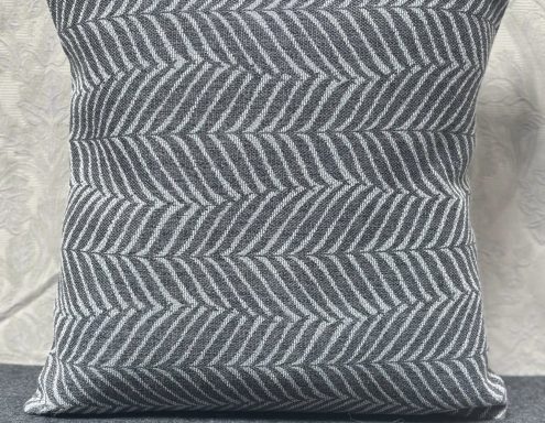 Grey cushion with a white herringbone pattern.