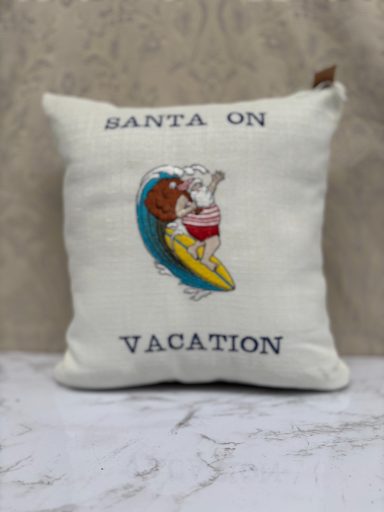 Cushion featuring Santa and a dog on a surfboard, captioned "Santa On Vacation."