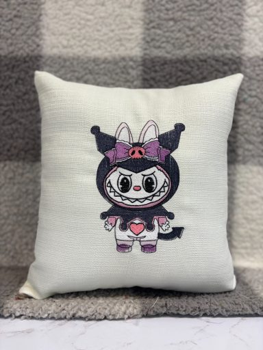 A cute cushion featuring a character in a black and purple costume with bunny ears and a heart.