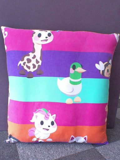 Colourful cushion featuring cartoon animals on striped background.