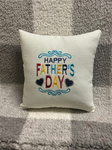 Cushion with "HAPPY FATHER'S DAY" embroidered in colourful letters.