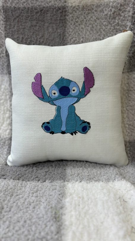 Square cushion featuring a cartoon character with blue fur and purple ears.