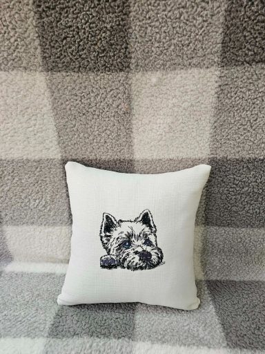 A decorative cushion featuring a sketch of a dog’s head on a textured background.